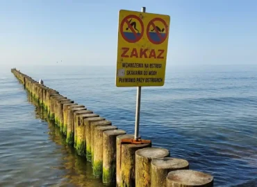 Znak ostrzegający przed ostrogami na plaży jako przykład na kontekst w bezpieczeństwie ruchu drogowego.