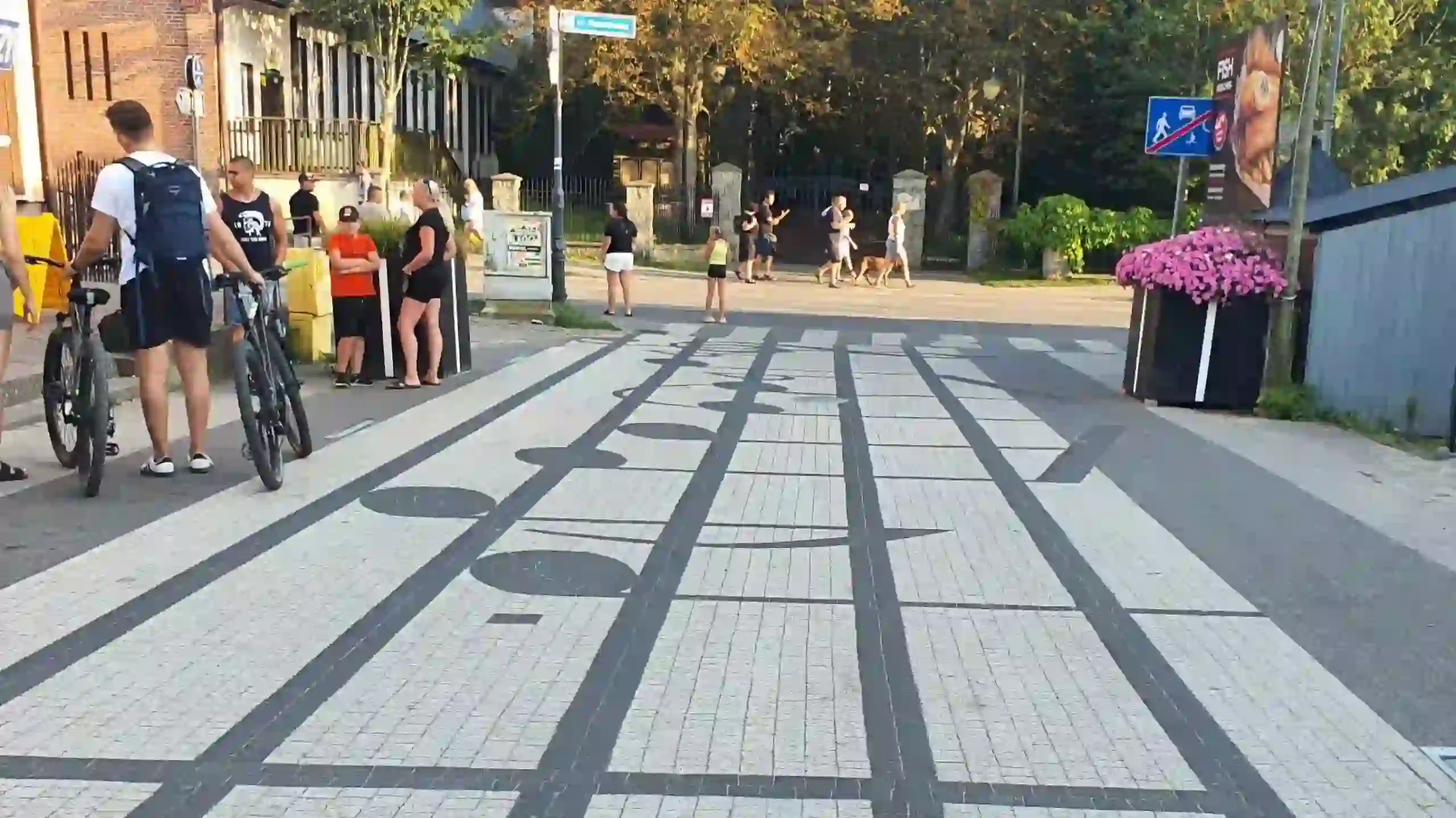 Prawidłowo zaprojektowana strefa zamieszkania typu woonerf, gdzie przejście dla pieszych w formie nut na pięciolinii skutecznie uspokaja ruch.