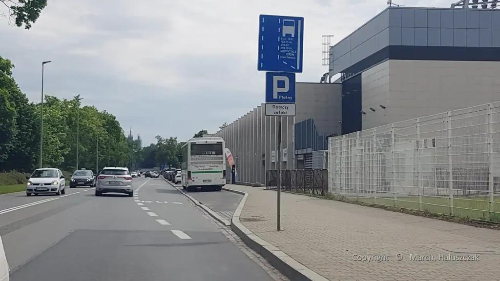Nieczytelny znak D-11 "Pas ruchu dla autobusów" z nadmiarem informacji, co ilustruje problem małej czcionki.